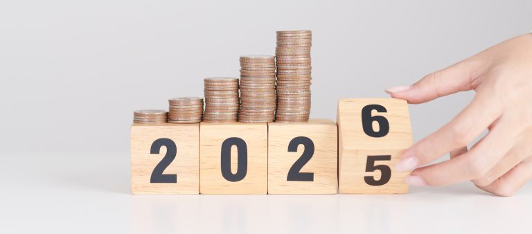 Geldstapel auf der Jahreszahl 2025, die zu 2026 wechselt